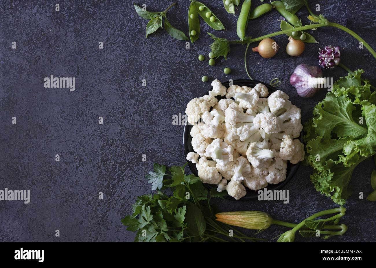 Cauliflower with vegetables and spices on a dark wooden background Stock Photo