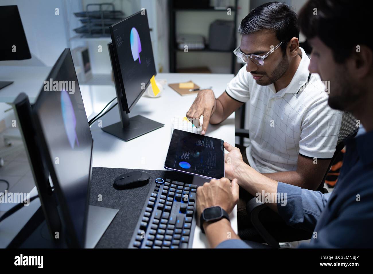 Software Developers Reviewing AI Data On Tablet In Tech Office Stock Photo