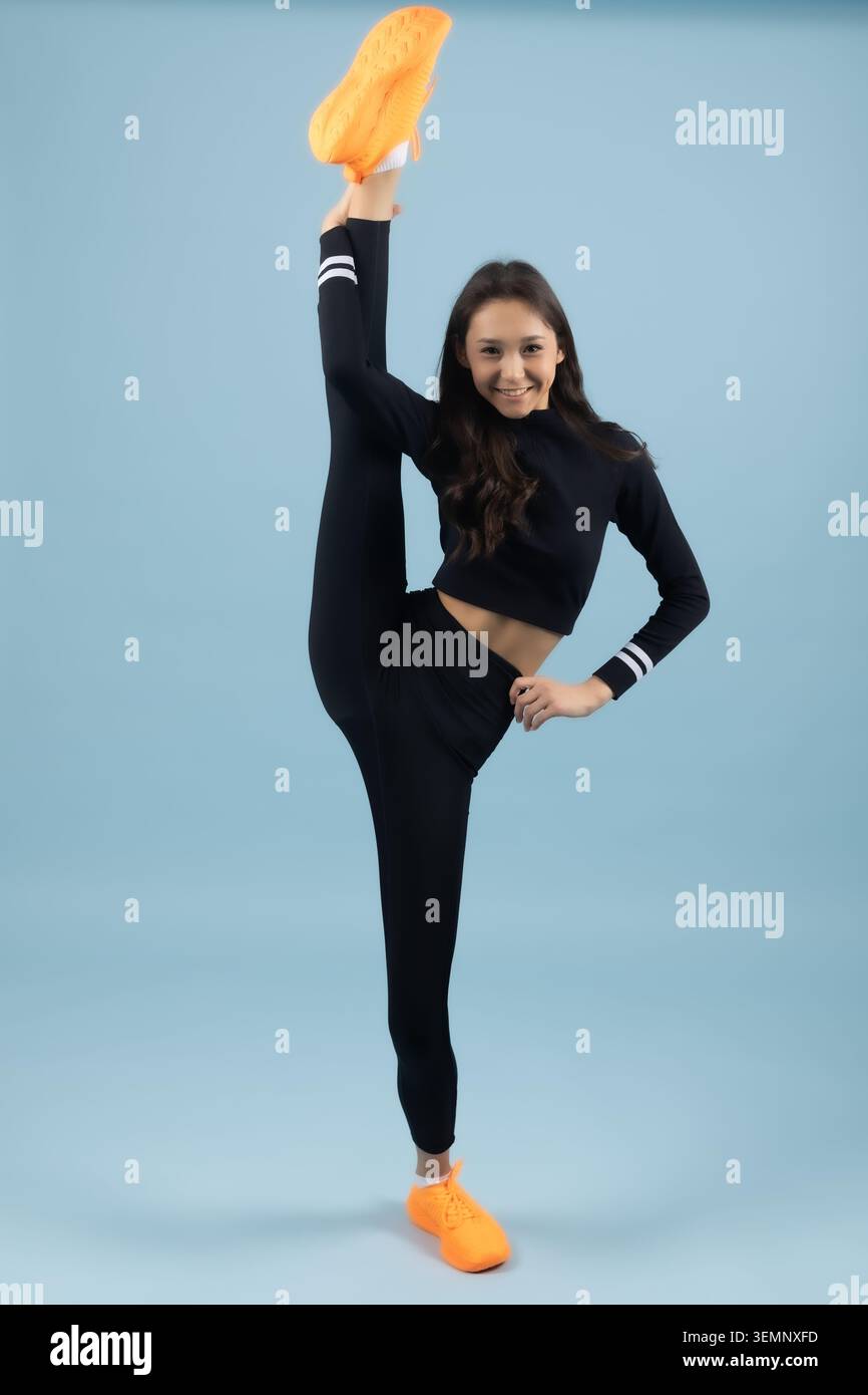 Incredible young woman standing on one leg doing full vertical split Stock Photo
