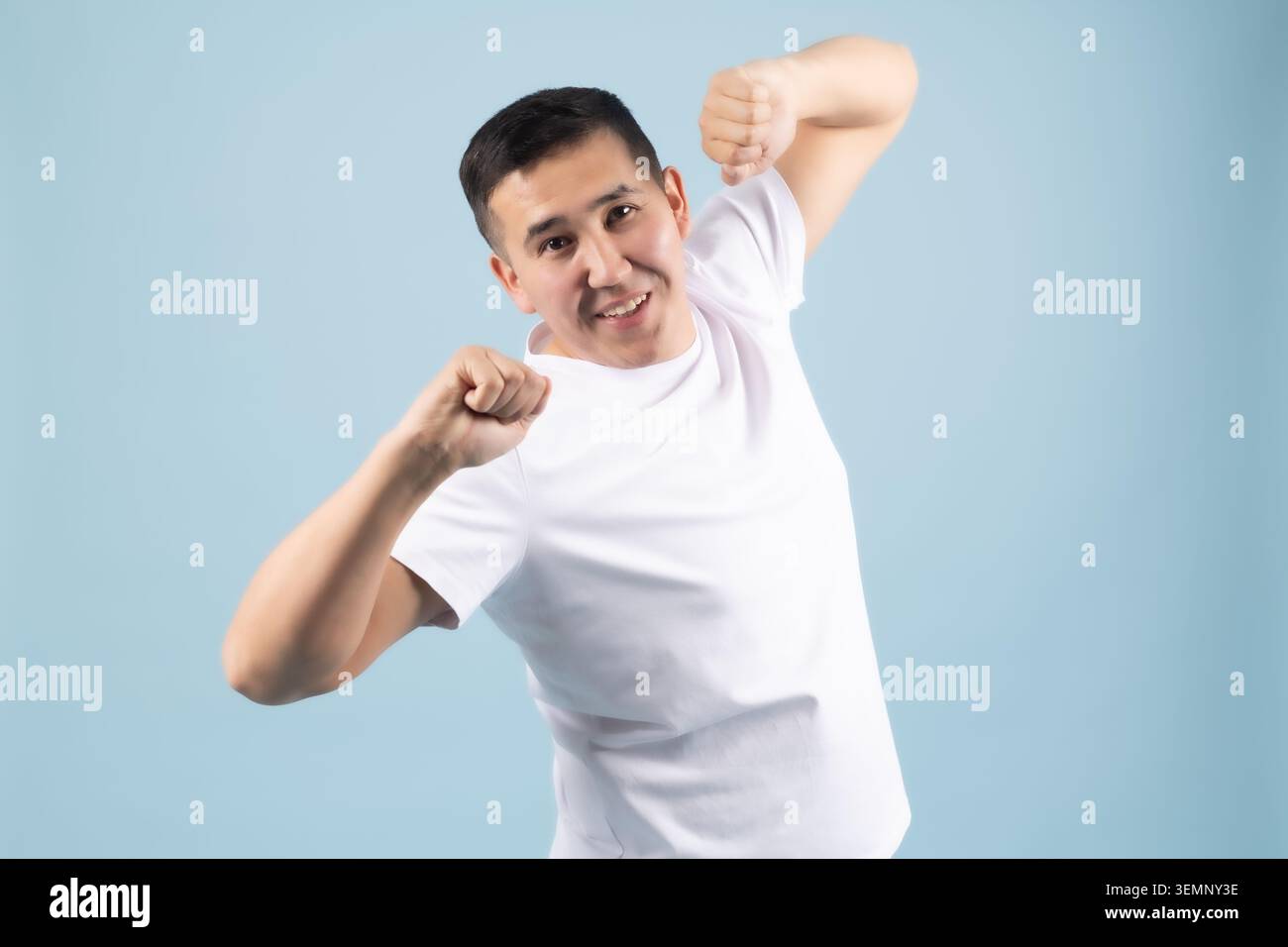 Energetic young man celebrating success shouting with joy in studio Stock Photo
