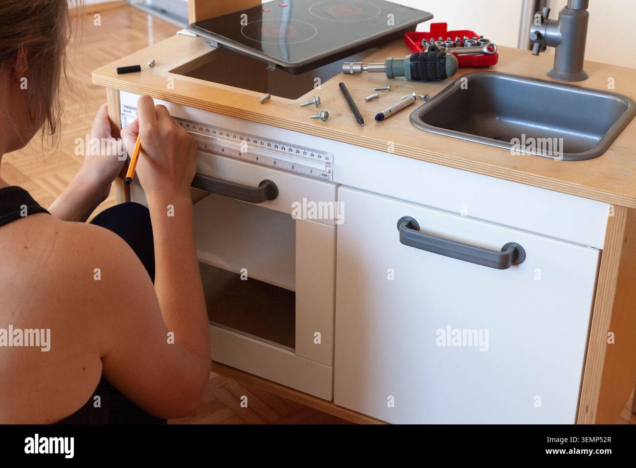 Marking drilling points on cabinet using ruler and pencil Stock Photo