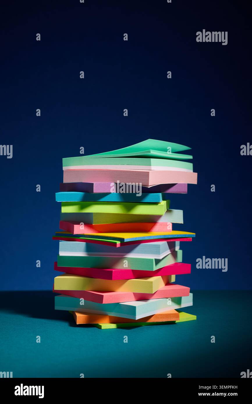 Tall jumbled stack of colorful sticky notes Stock Photo