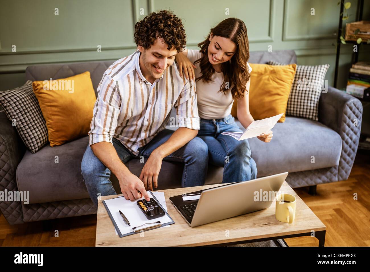 Young couple calculating home finances while checking bills. Stock Photo