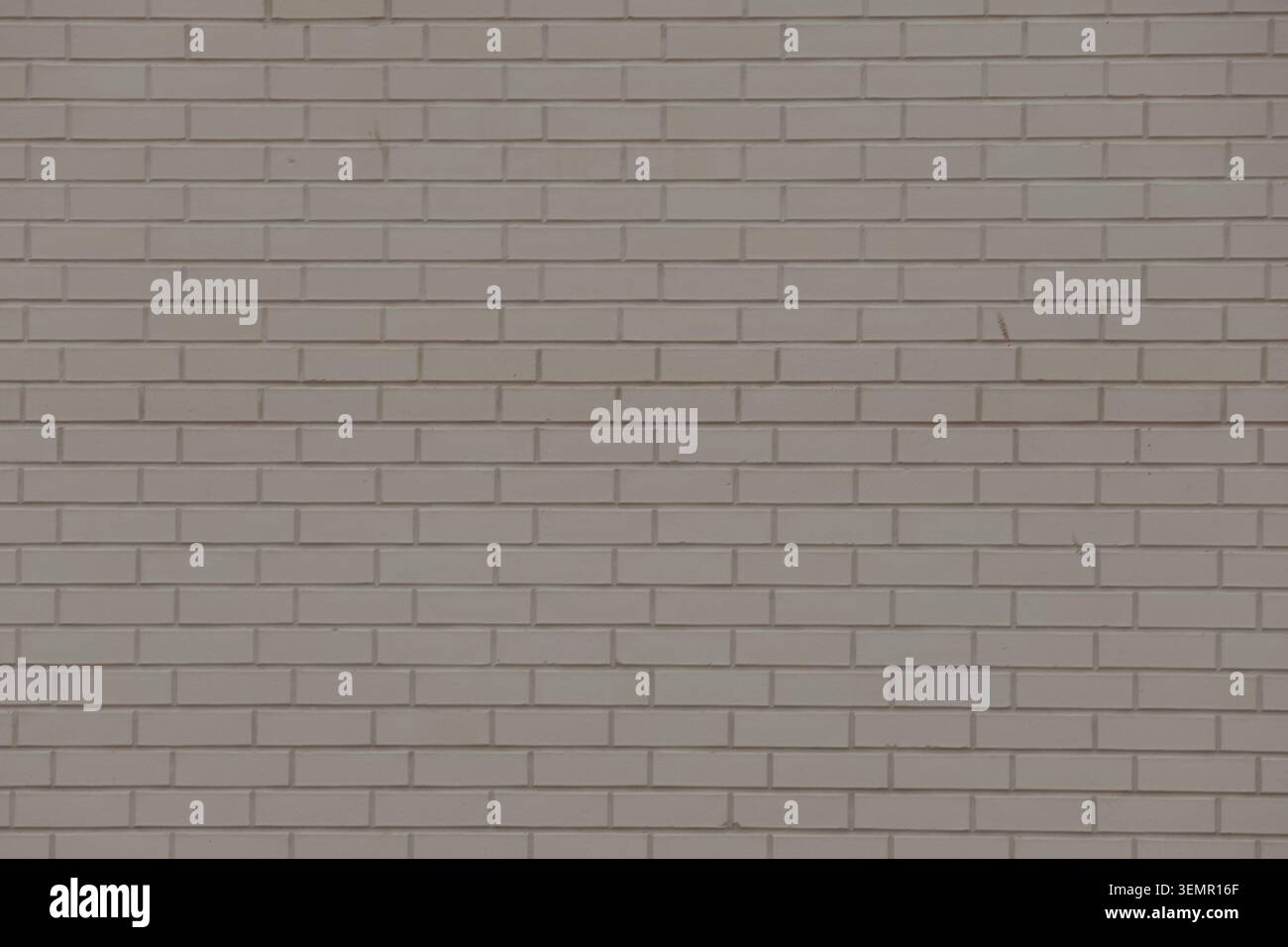 Weathered light gray stone wall texture with rectangular blocks and cracks Stock Photo