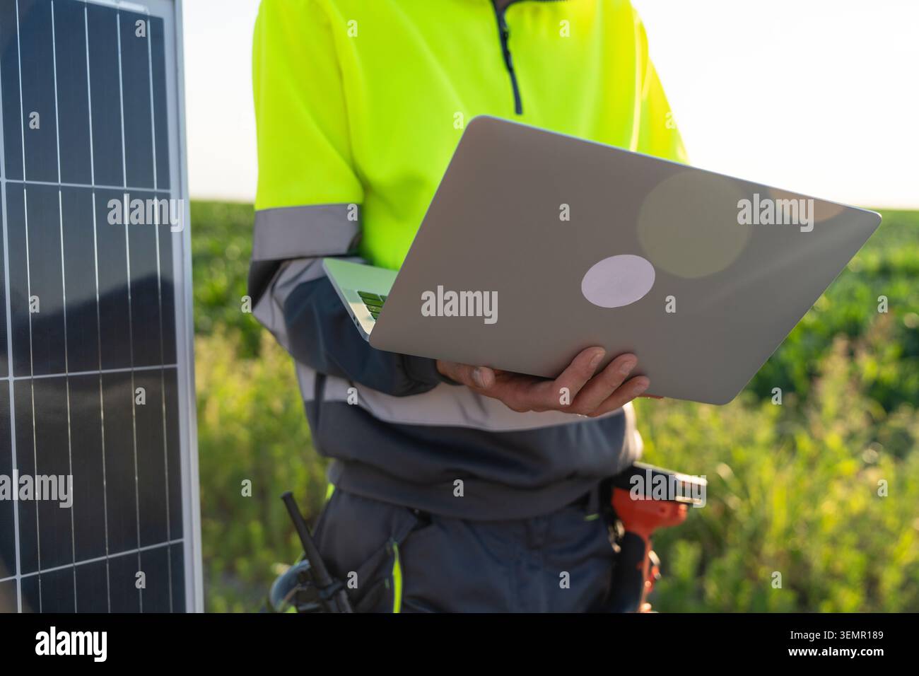 Engineer with laptop next to solar panel. Stock Photo