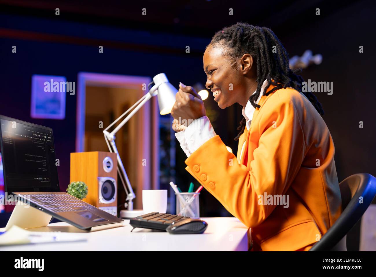 Happy developer at laptop programming, exuberating after writing lines of code, using development tools, ecstatic woman in home office pleased after finishing debugging software on notebook. Stock Photo