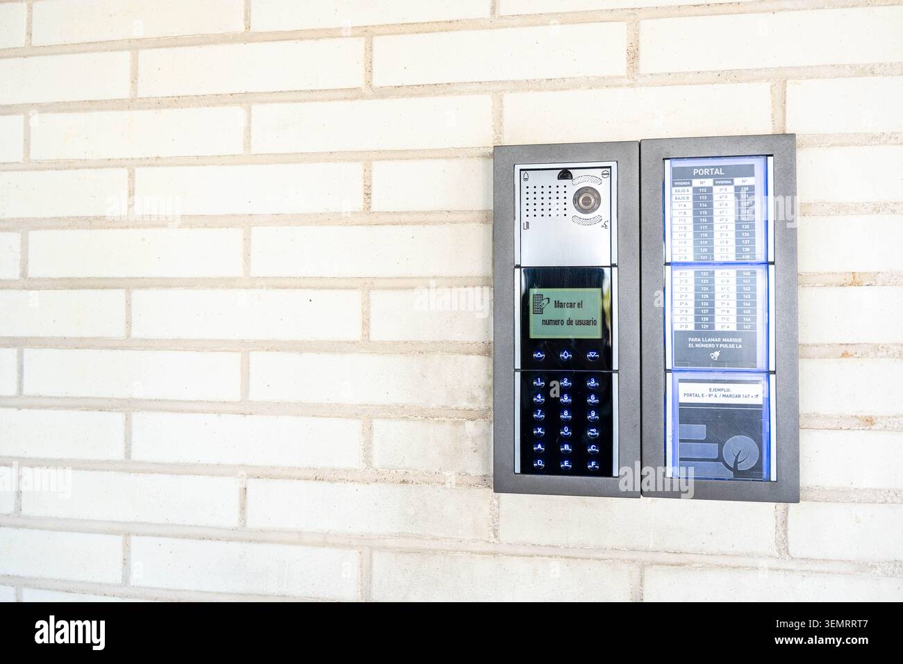 Modern electronic intercom and access keypad on a white brick wall Stock Photo