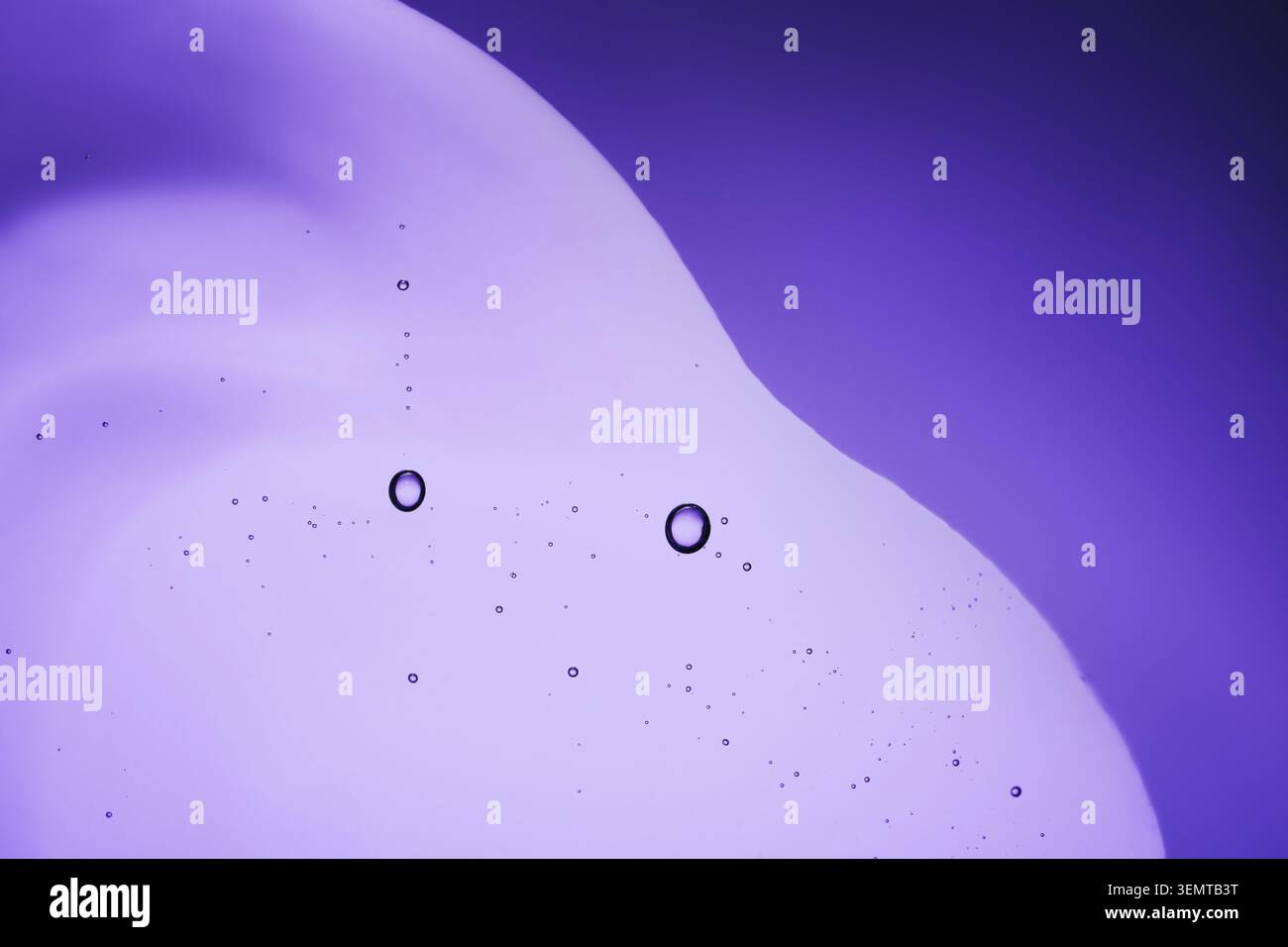 Serum with bubbles on purple background, close-up Stock Photo
