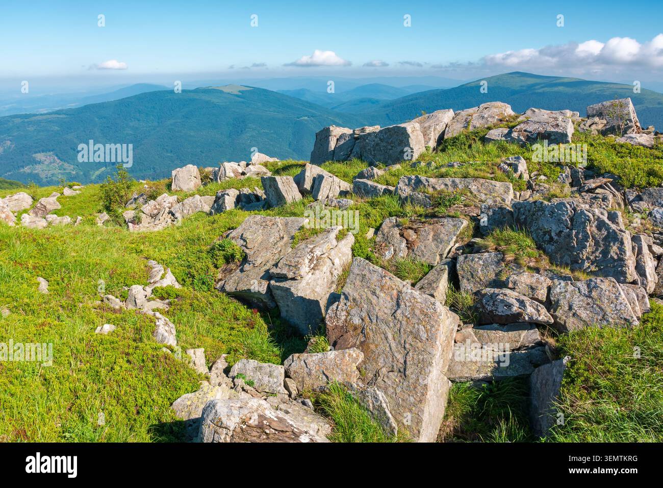 mountain landscape with stones and grass. view of carpthian mountains in summer. white sharp stones on the rolling hills on top of mountain range unde Stock Photo