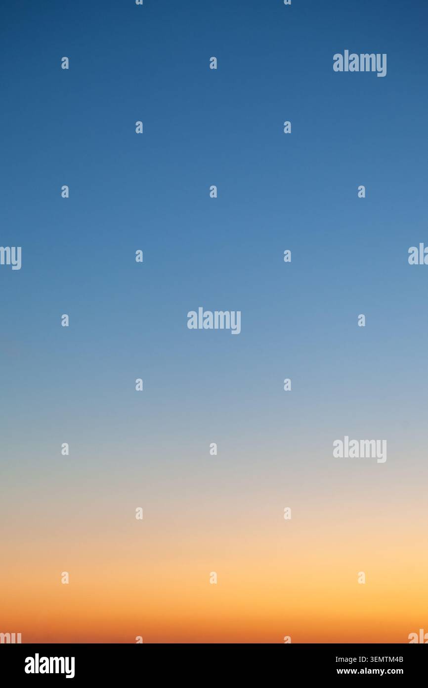 Clear and empty blue and yellow orange gradient sky for background, vertical image Stock Photo
