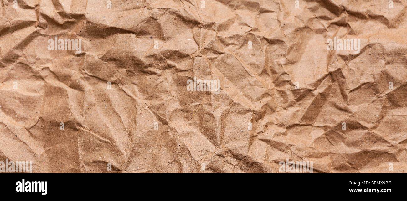 Crumpled brown kraft paper texture background, recycled packaging material, sustainable eco-friendly design element Stock Photo
