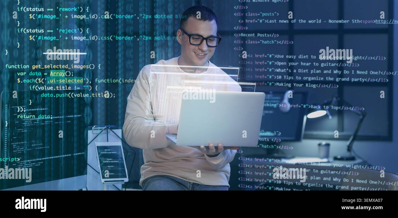 Smiling male programmer working on laptop with overlayed code, software development and digital technology Stock Photo