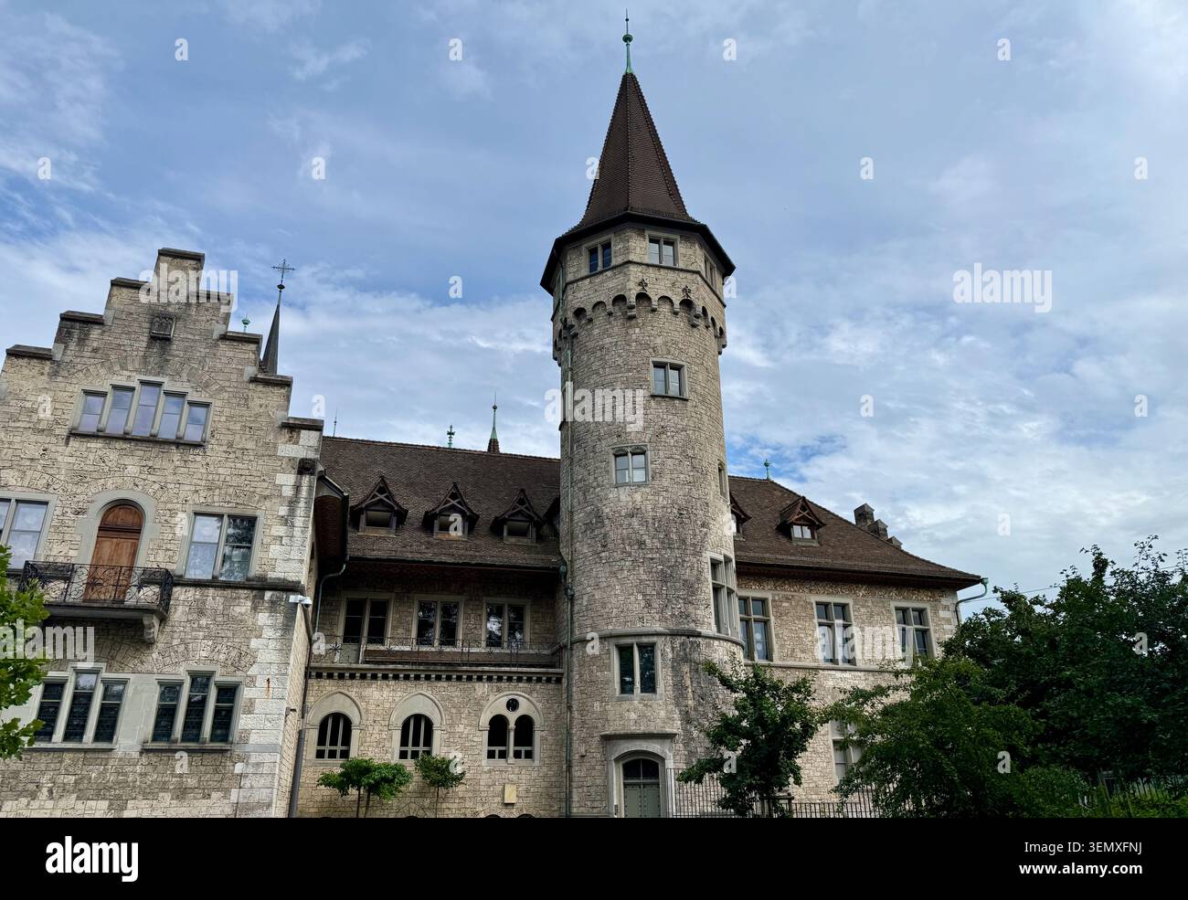 A medieval Swiss castle with a round tower, set against a clear blue sky. - Smartphone Captured Stock Image