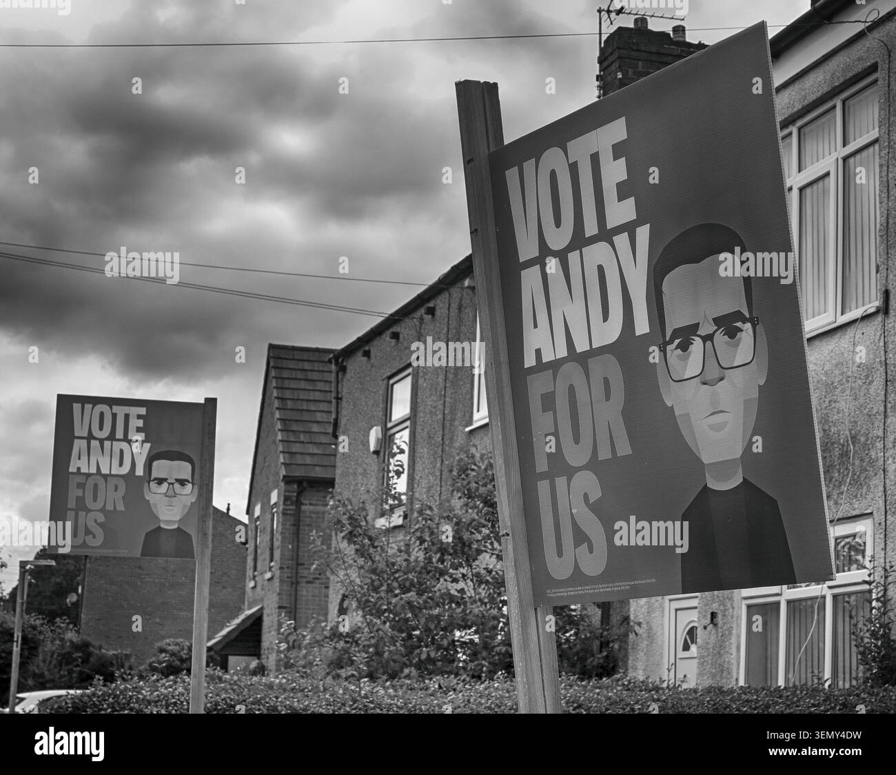 Moody skies ahead - Labour by-election posters Vote Andy For Us Burnham outside terraced homes in Hindley, Makerfield, Greater Manchester. Stock Photo