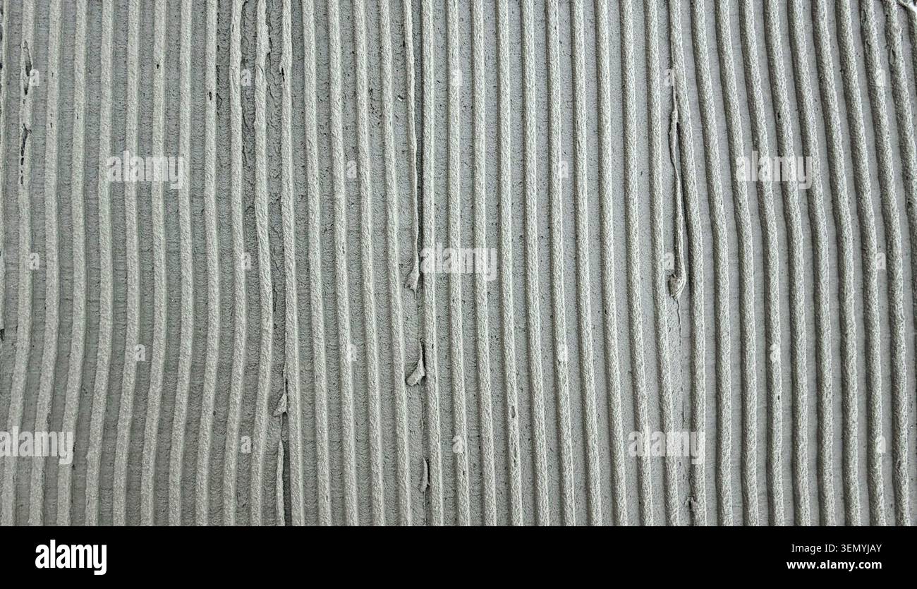 Textured gray cement surface with parallel grooves and ridges Stock Photo