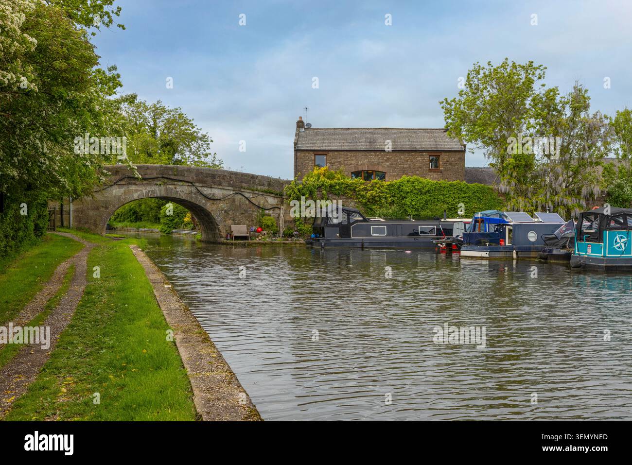 Tranquil waters and moored narrowboats on the historic Lancaster Canal at Galgate in Lancashire, North West England. Stock Photo