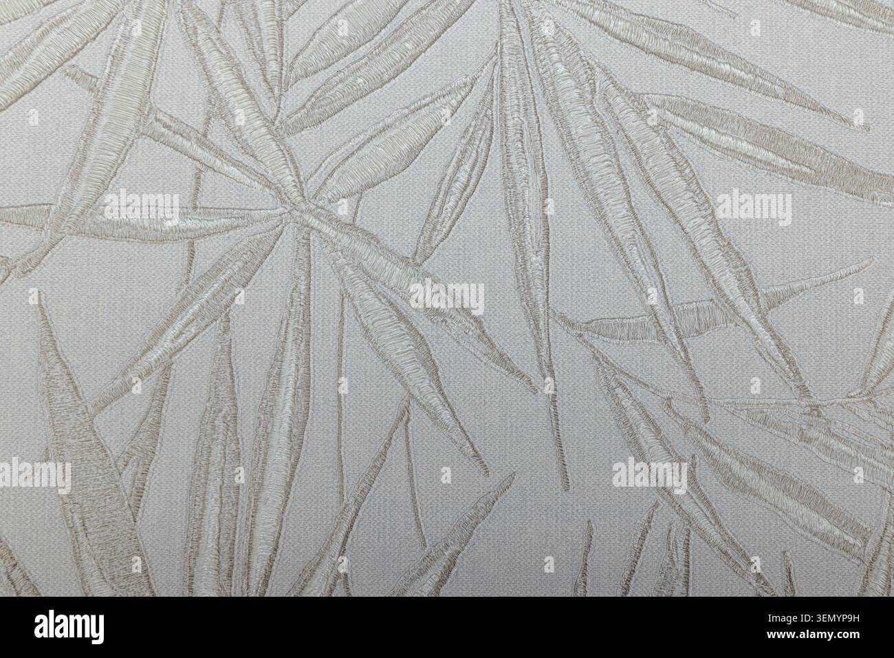 Minimalist bamboo leaf pattern on a textured fabric tapestry Stock Photo