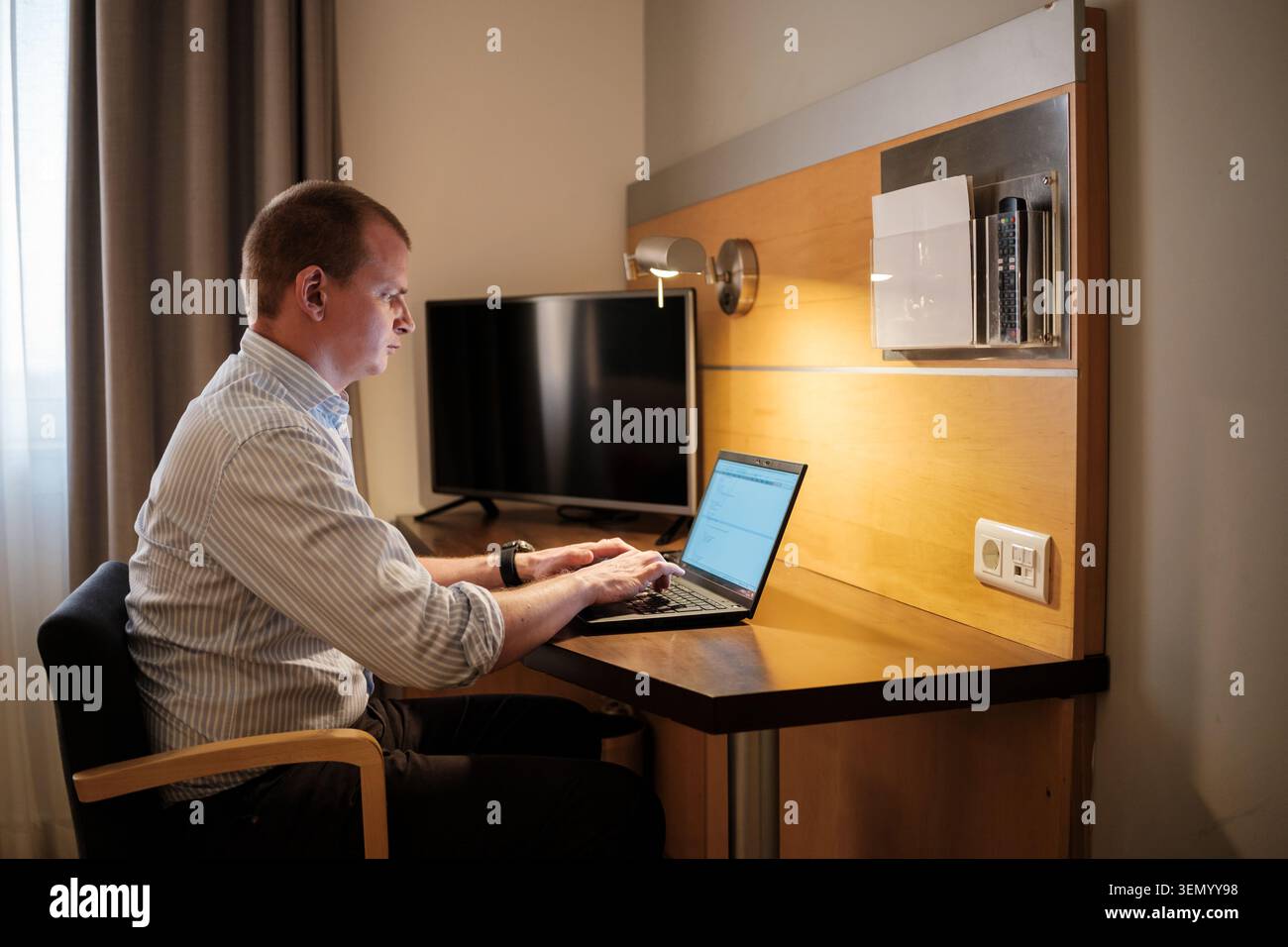 Man using laptop for business while traveling, focusing on remote work Stock Photo