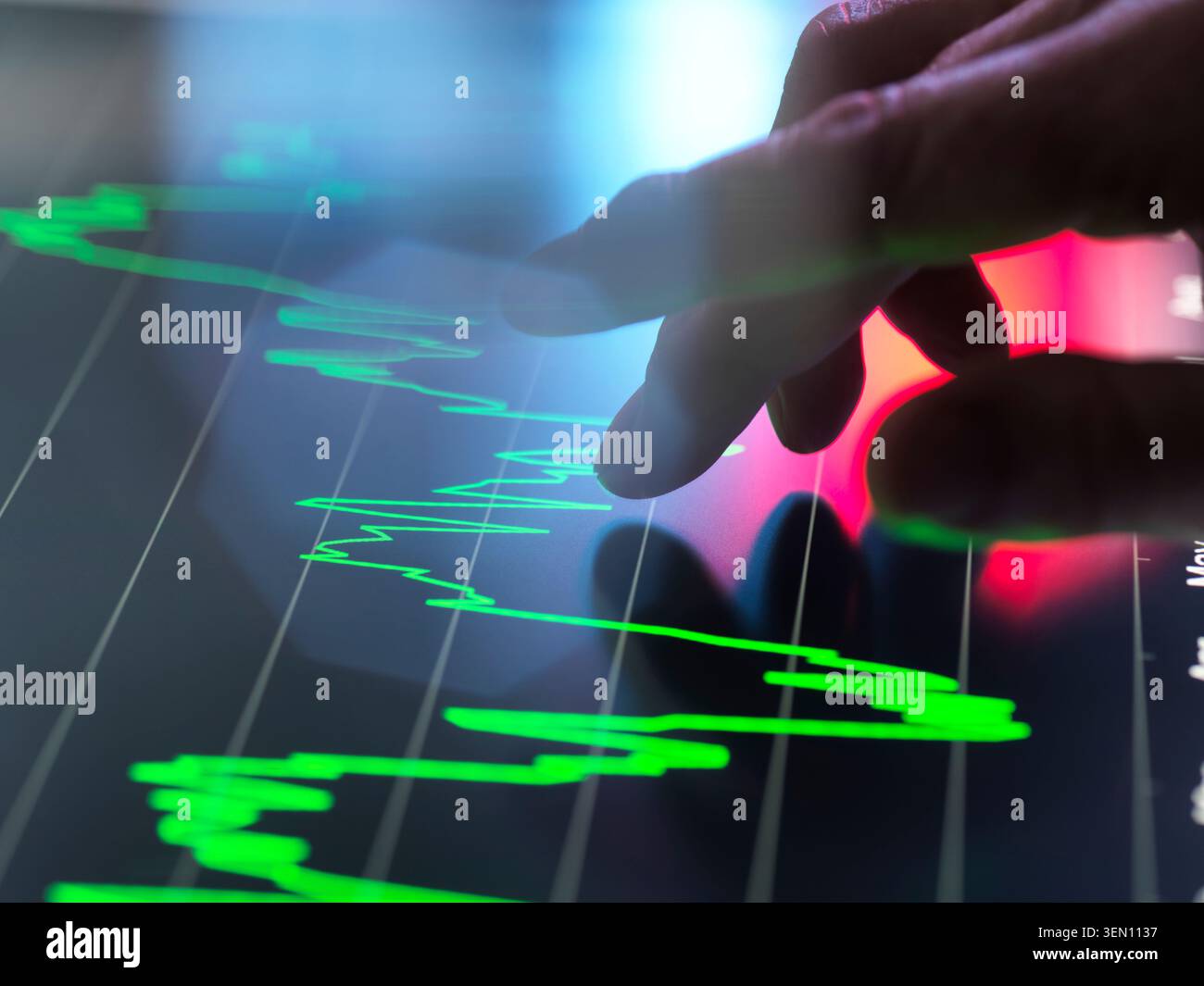 Hand interacts with financial graph on a touchscreen in a high-tech setting. Stock Photo