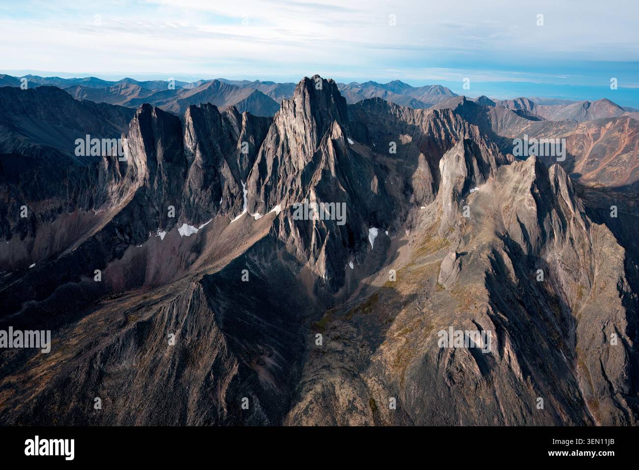 Rugged mountain range with sharp peaks under a clear blue sky. Stock Photo