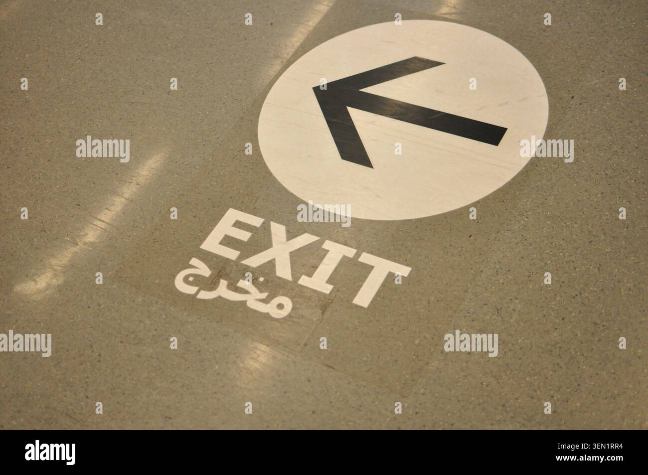 black arrow pointing left in a white circle on the floor with the ...