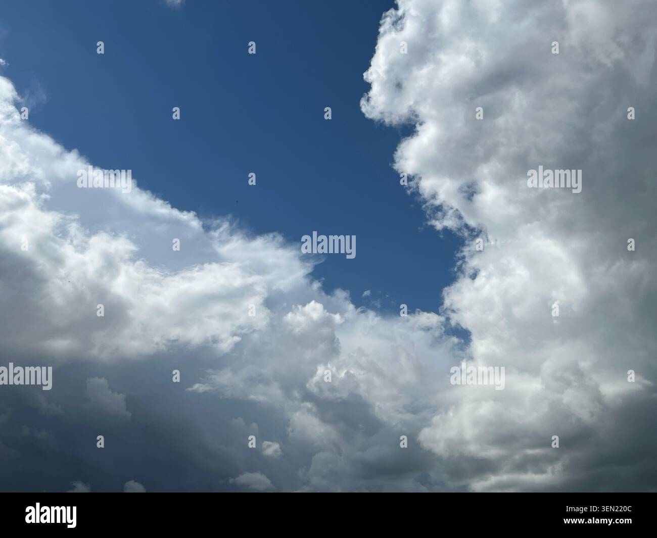 Dramatic sky with fluffy white clouds against a deep blue expanse Stock Photo