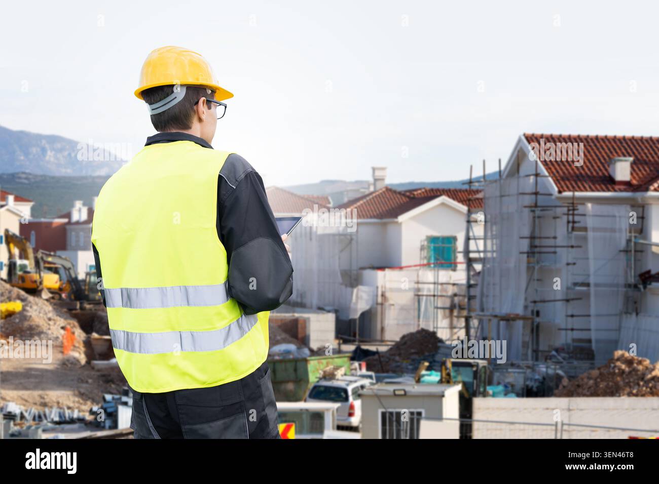 Сivil engineer with tablet computer looking at construction site Stock Photo