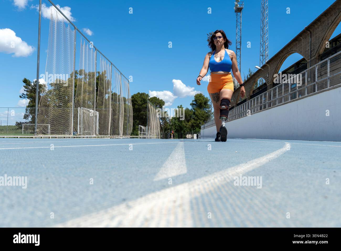 Amputee athlete walking on running track with prosthesis Stock Photo