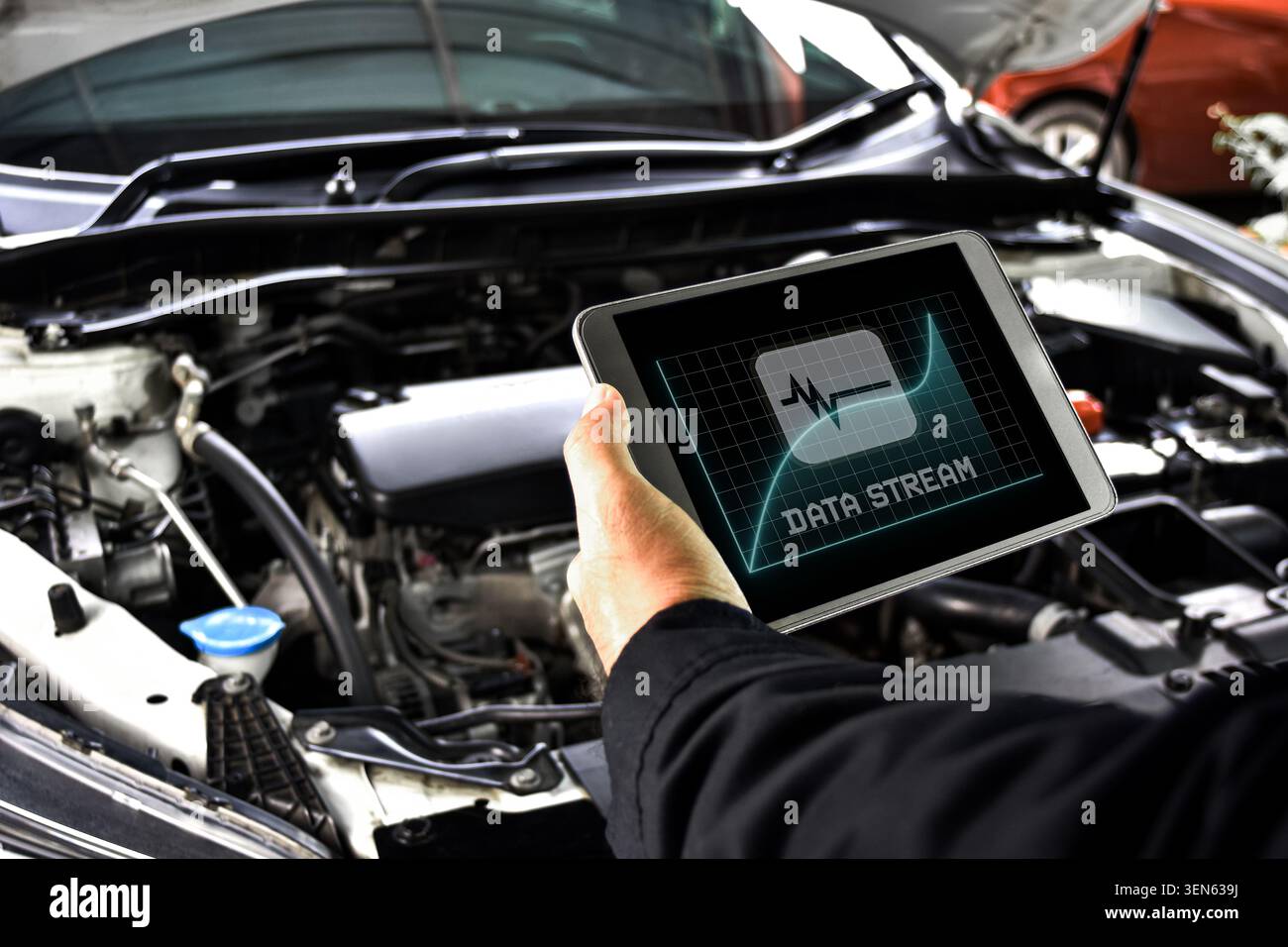 Mechanic diagnostics engine car using digital obd2 scanner tablet with data stream software at auto repair shop Stock Photo