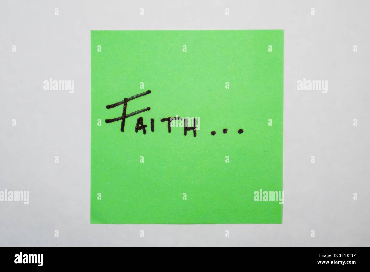 The word faith on a green Post-it sticker Stock Photo