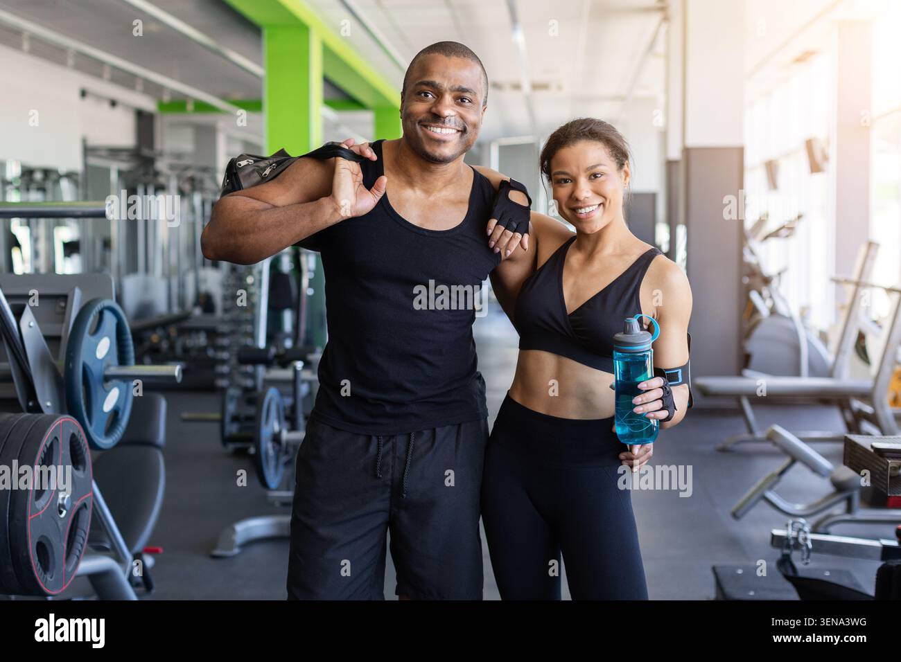 Black standing together in gym with bag and water after training Stock Photo