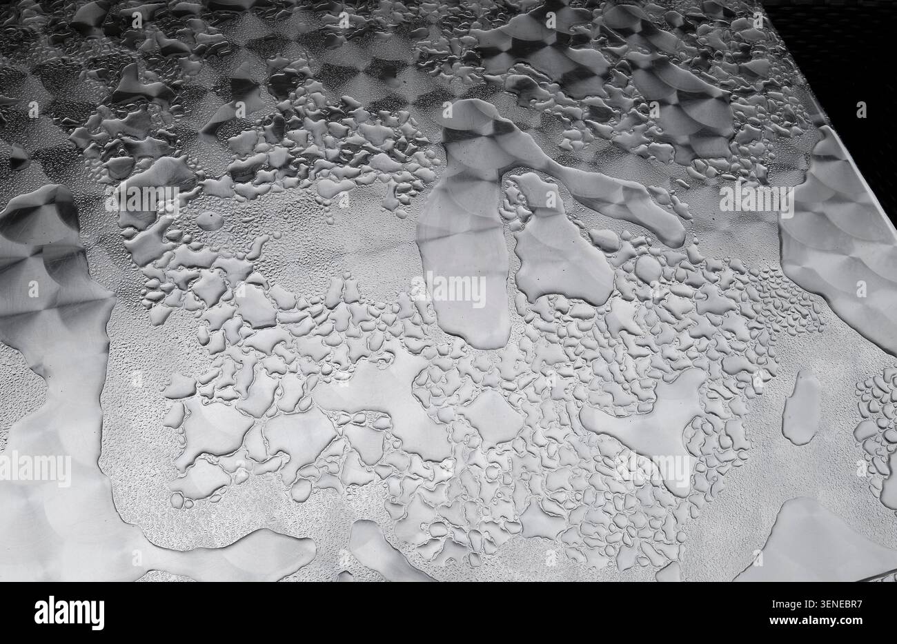 rain drops on patterned metal cafe table top, yorkshire, england Stock Photo