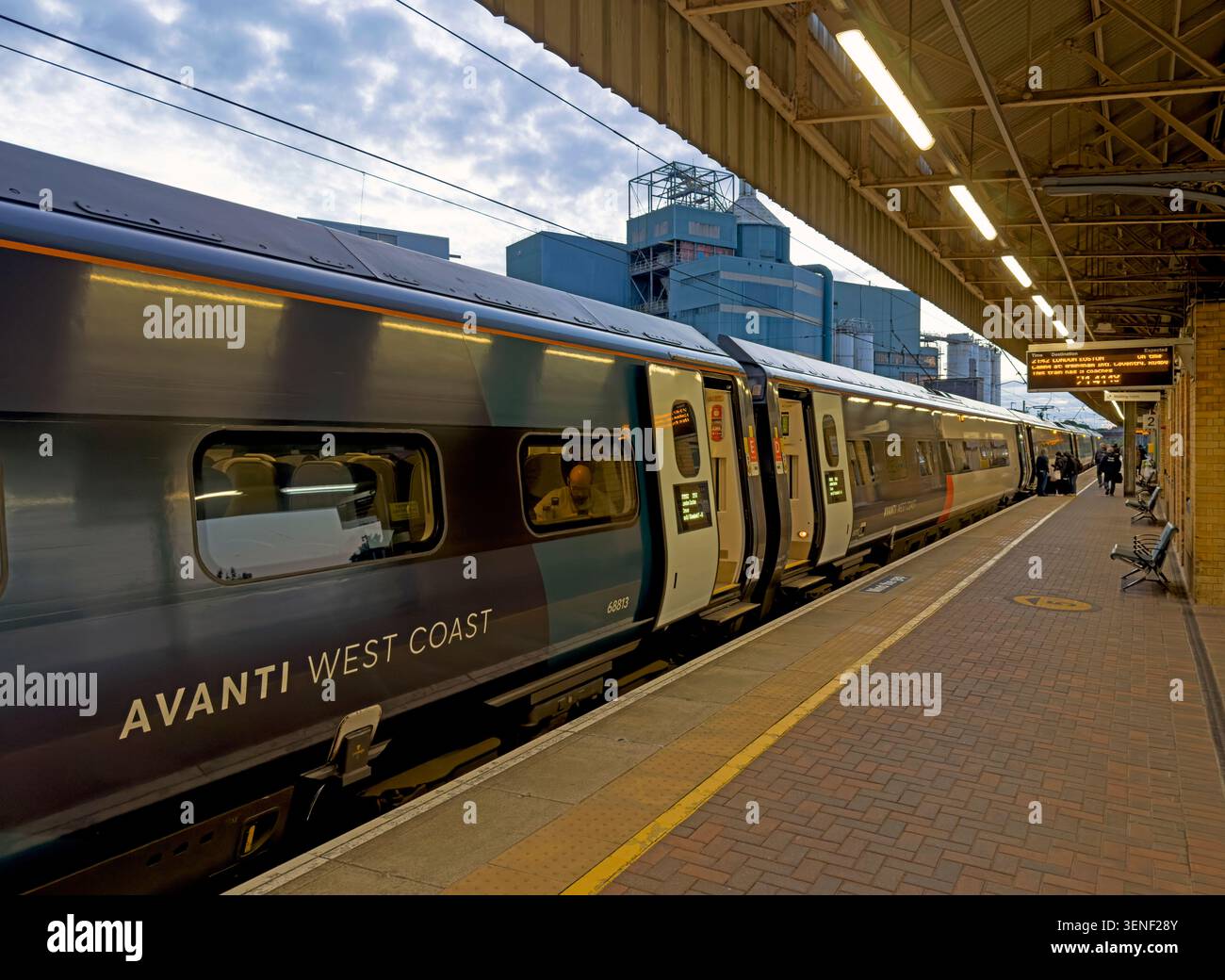 Evening WCML Edinburgh intercity service at Warrington Bank Quay, with Avanti West Coast train boarding for London Euston Stock Photo