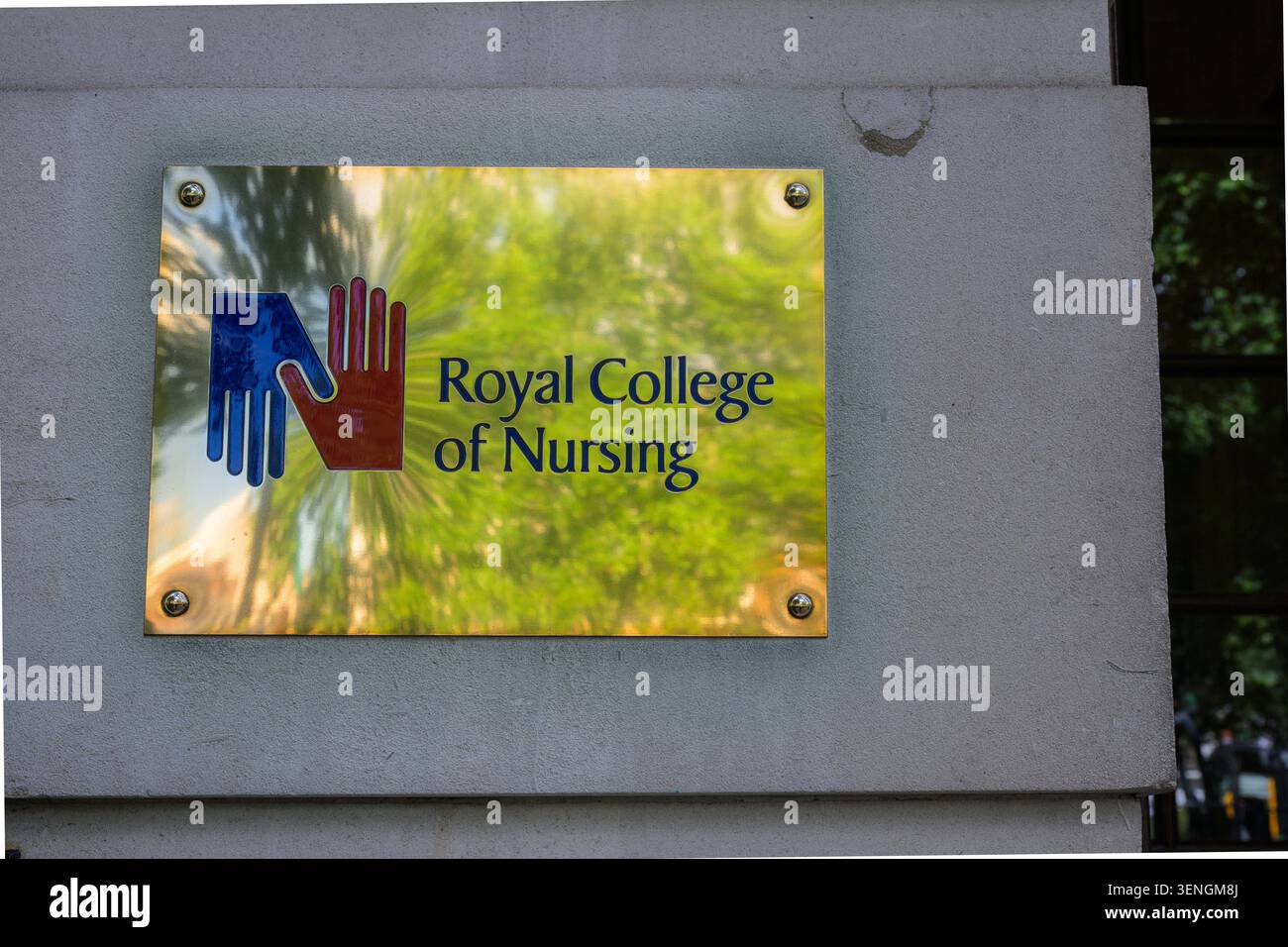 Reflective plaque displaying the Royal College of Nursing logo and name on a London building wall, symbolising healthcare professionalism and educatio Stock Photo