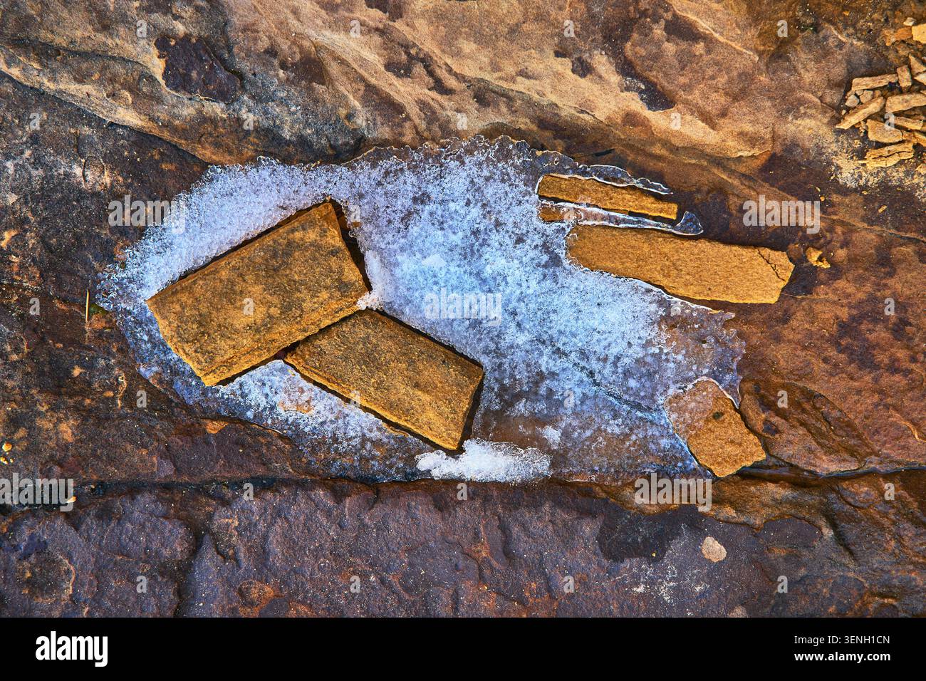 Snow and Sandstone Slabs on Rugged Rock Surface in Nevada Desert Stock Photo