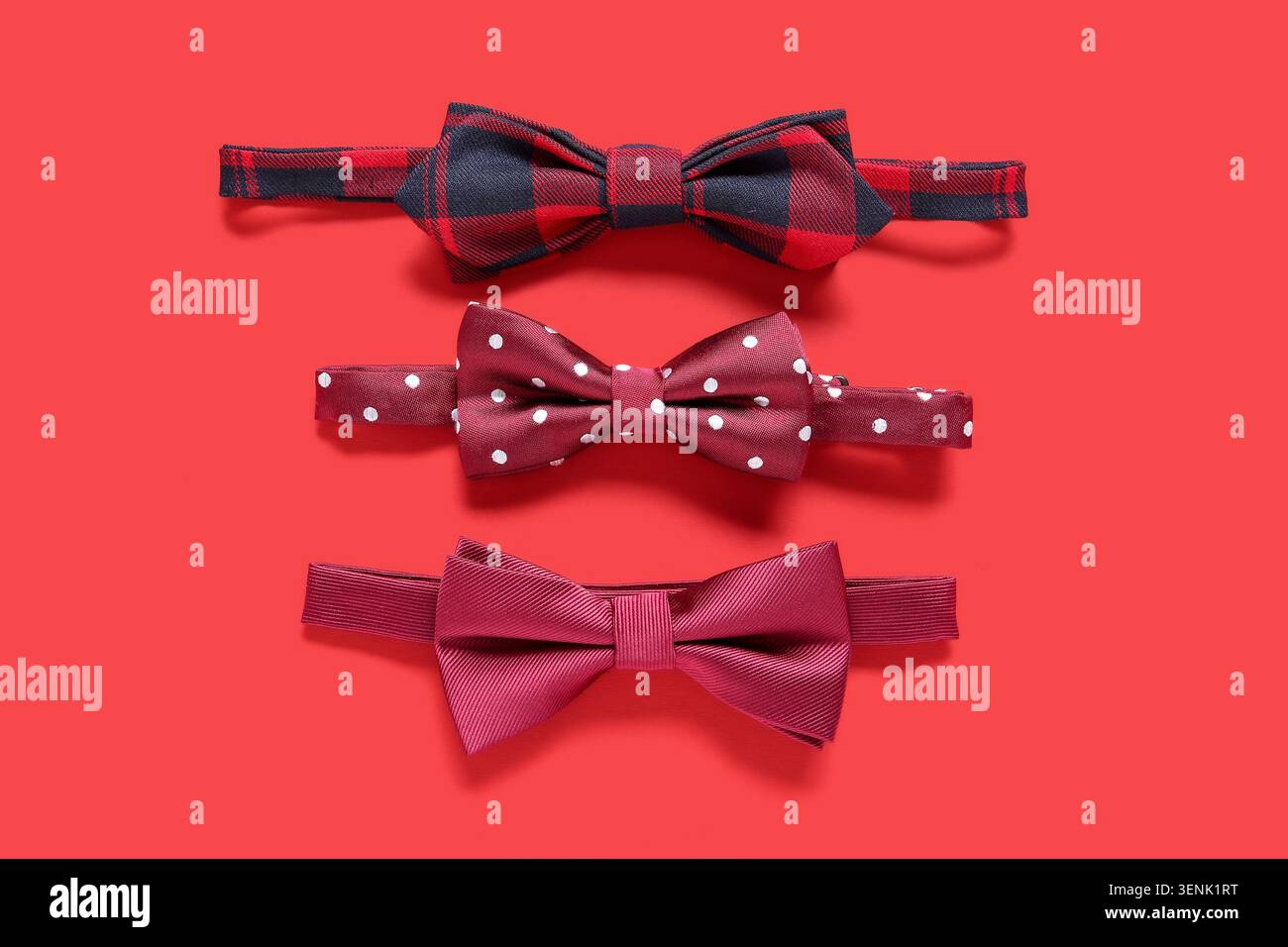 Different stylish bow ties on red background Stock Photo