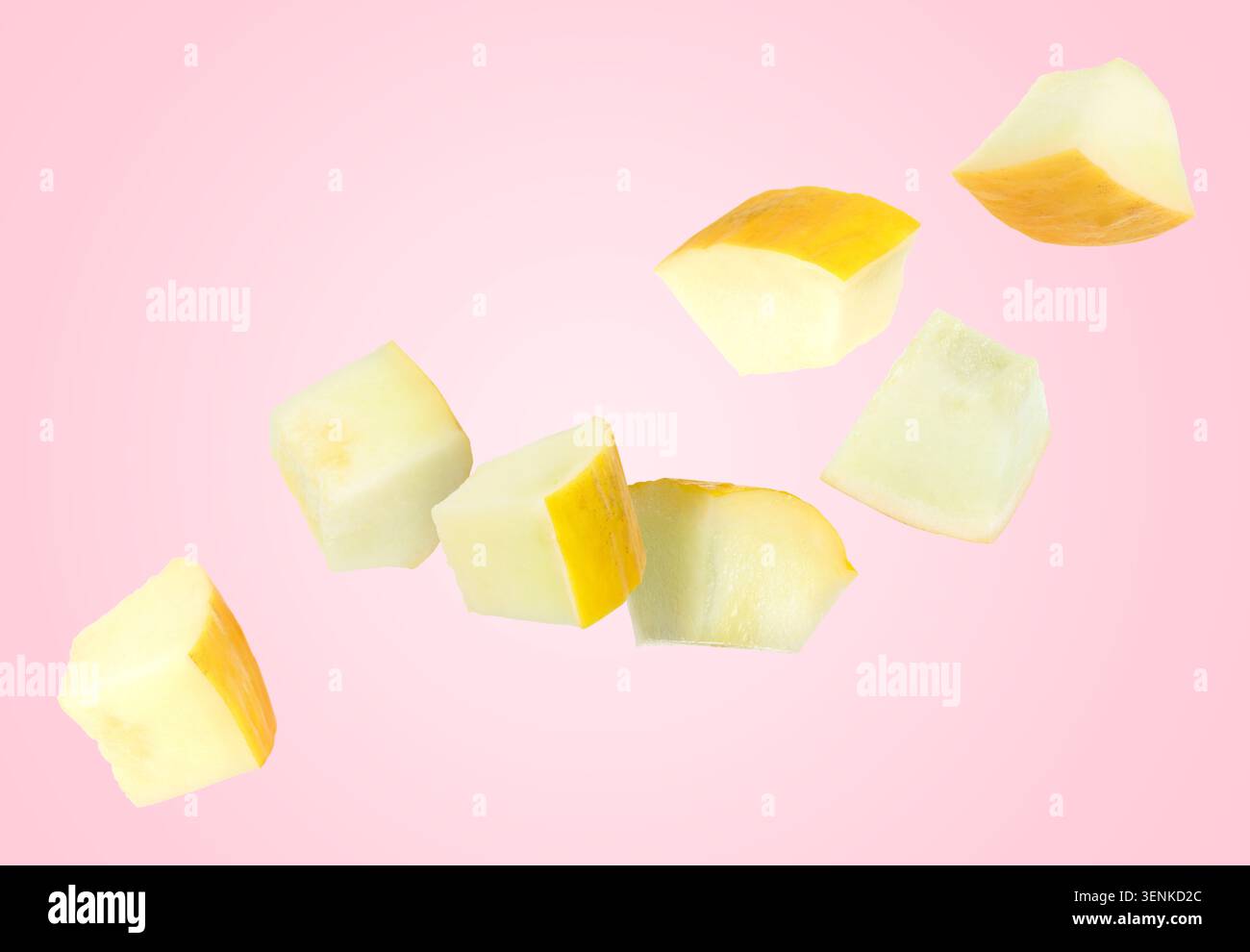 Sweet melon pieces flying in air against pink background Stock Photo