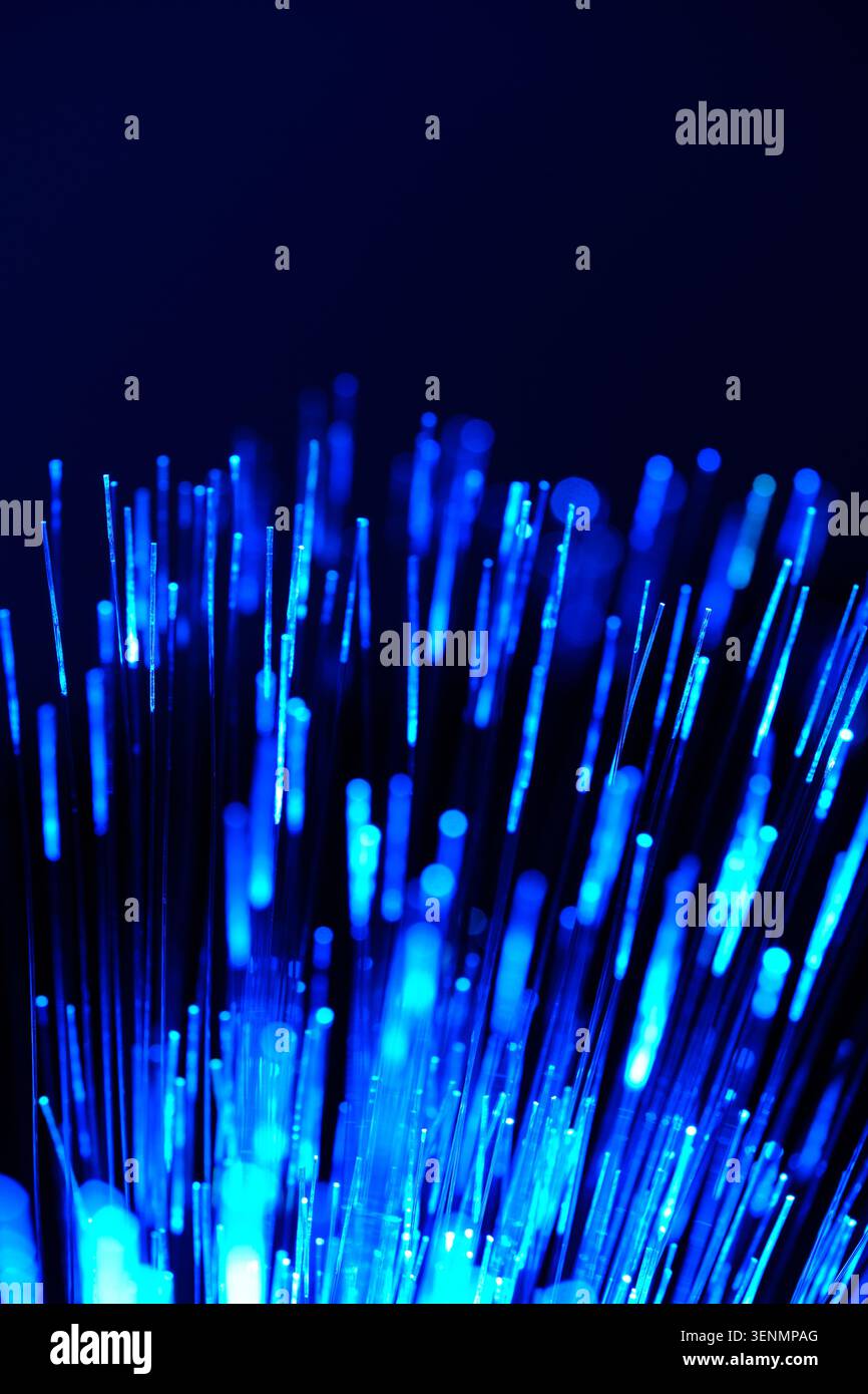 Glowing neon blue fiber optic cables bundle together creating bright high speed network texture Stock Photo