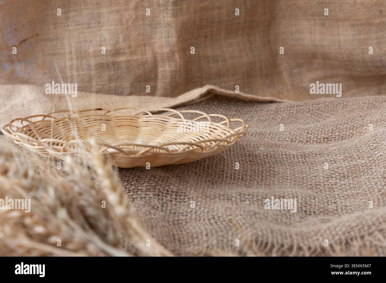Empty Wicker Bread Tray On Rustic Burlap With Wheat Ears Stock Photo
