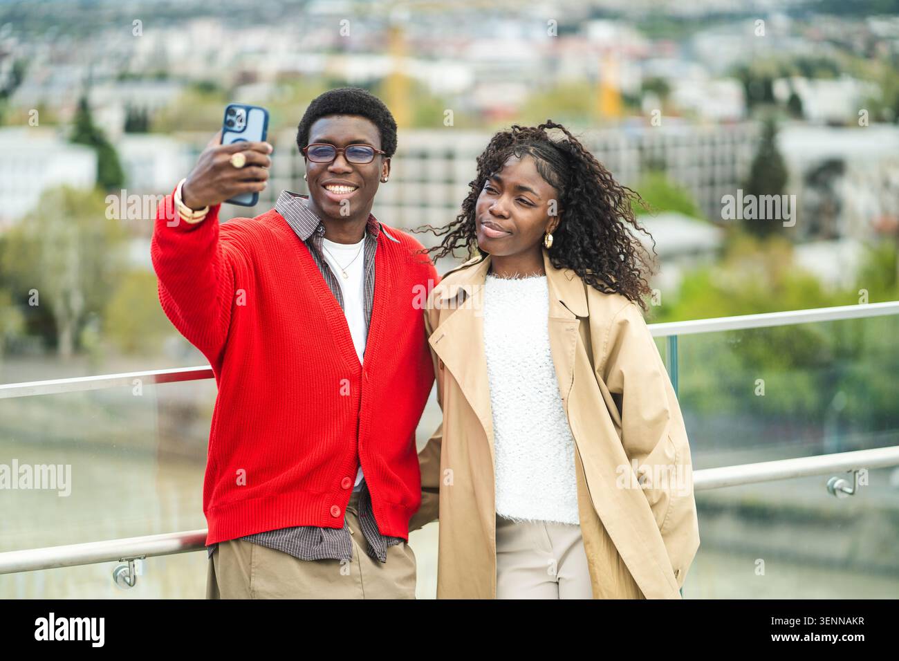 Happy african american married couple travelers posing at viewpoint in city taking selfie on phone. Stock Photo