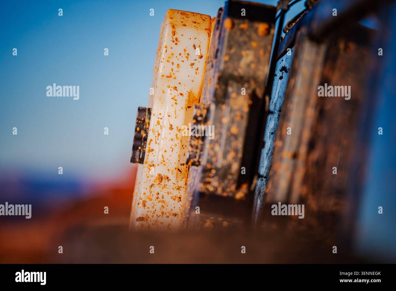 Mud splattered equipment sits under a clear blue sky Stock Photo