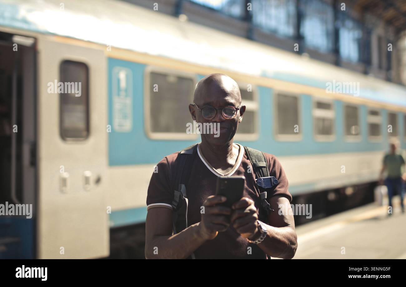 Happy man using smartphone at a train station Stock Photo