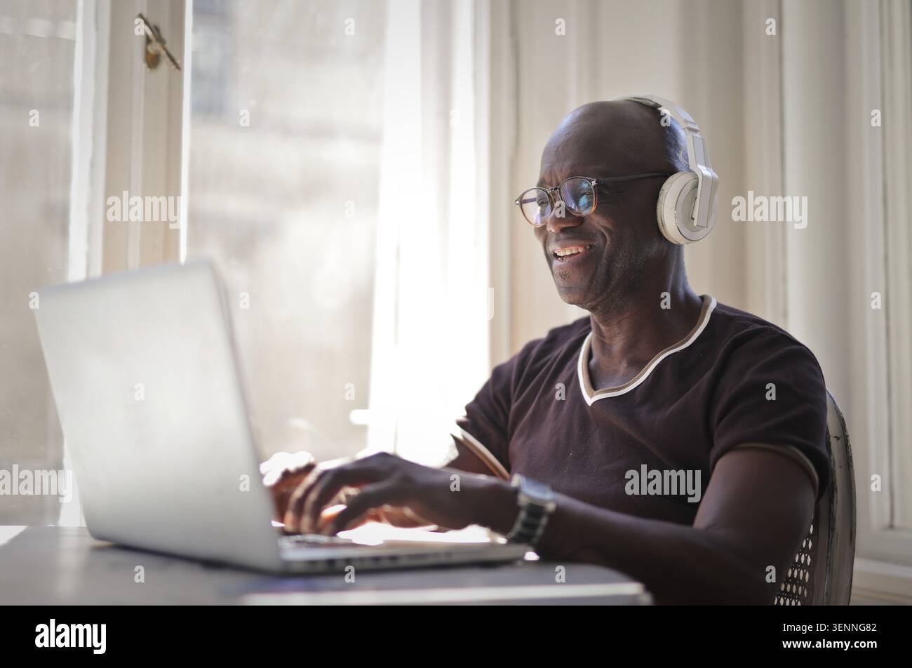 Smiling mature black man using a laptop computer at home Stock Photo