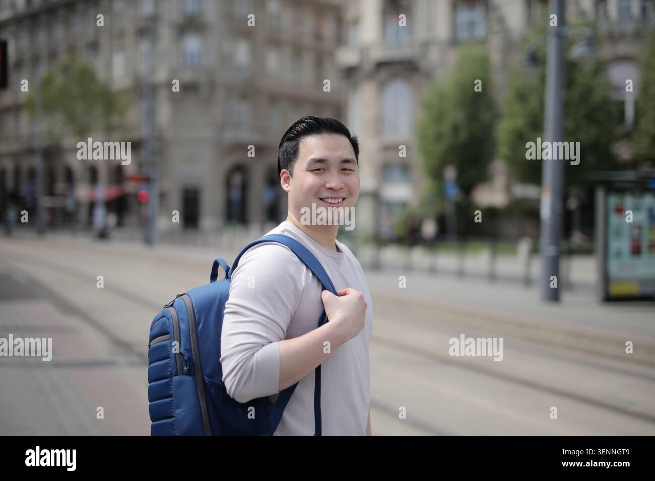 Happy young Asian man with a backpack in the city Stock Photo
