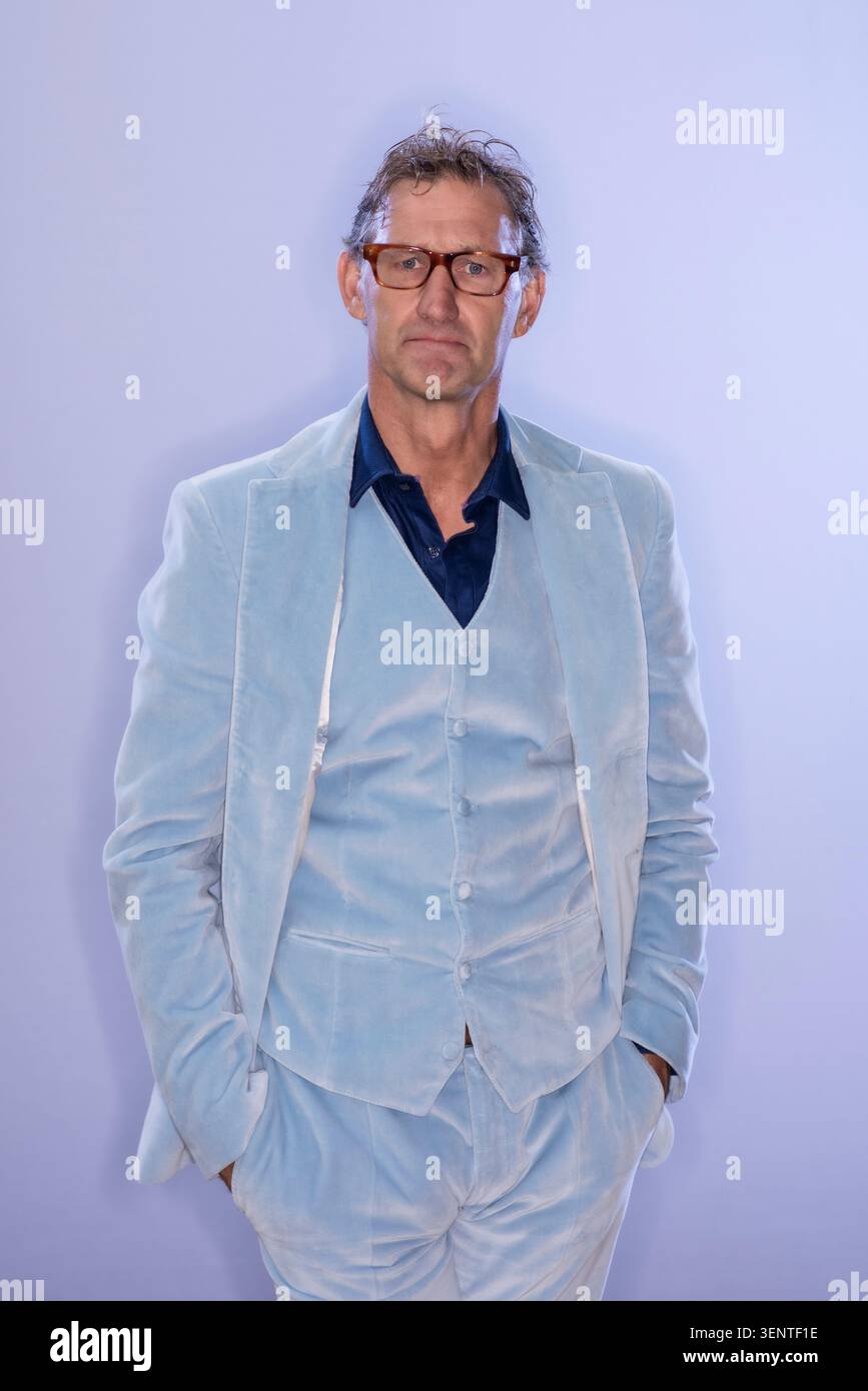 Portrait of former England Footballer and Manager Tony Adams in pale blue velvet suit. He is standing against a plain background Stock Photo