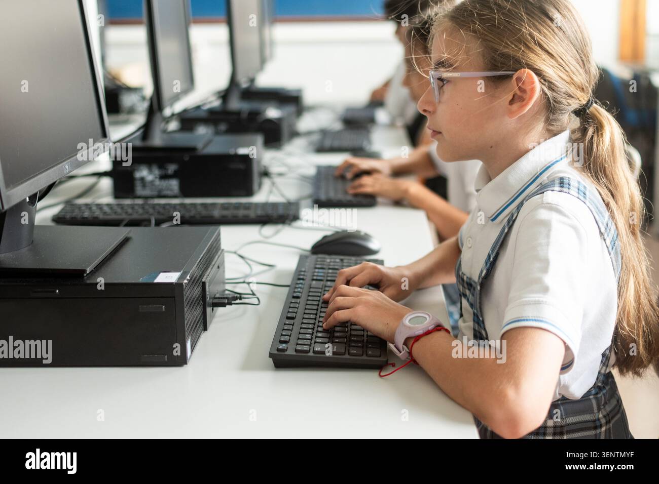 Focused primary school student typing on a desktop computer during an information technology class. Digital literacy, computer education, technology s Stock Photo