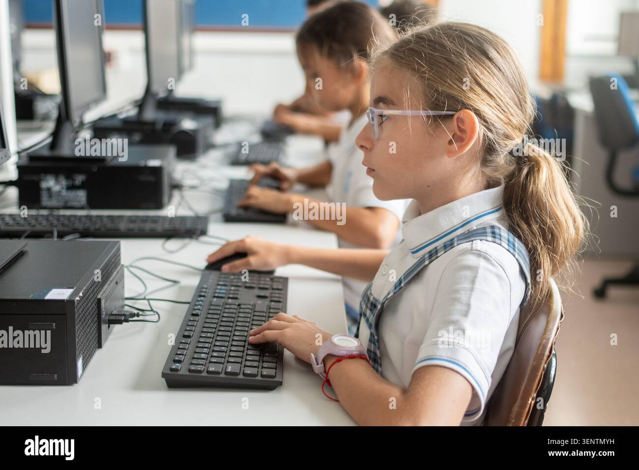 Focused primary school student typing on a desktop computer during an information technology class. Digital literacy, computer education, technology s Stock Photo
