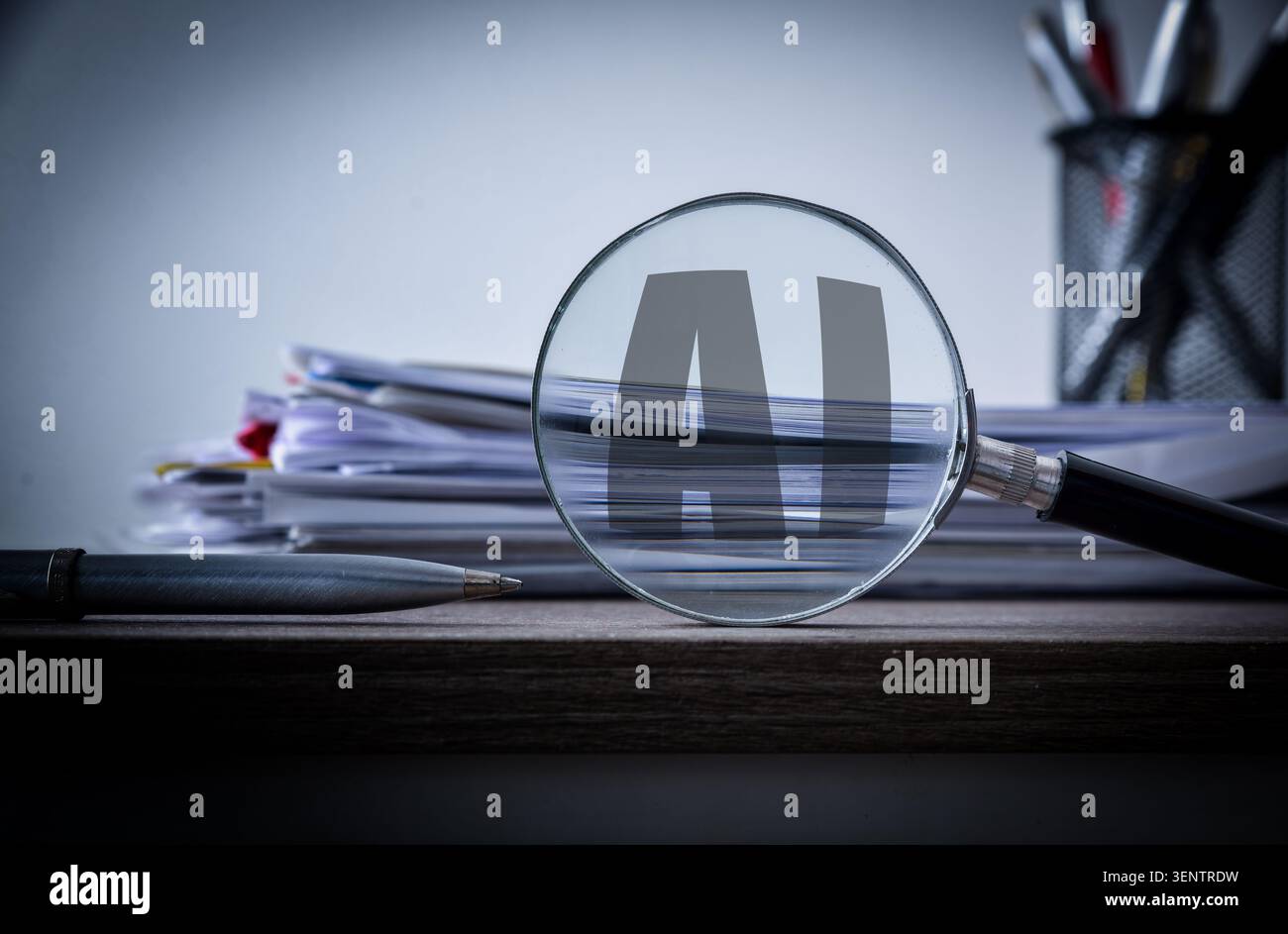 Magnifying glass highlighting AI letters over stacked documents on a desk, representing artificial intelligence, data analysis, auditing, technology, Stock Photo