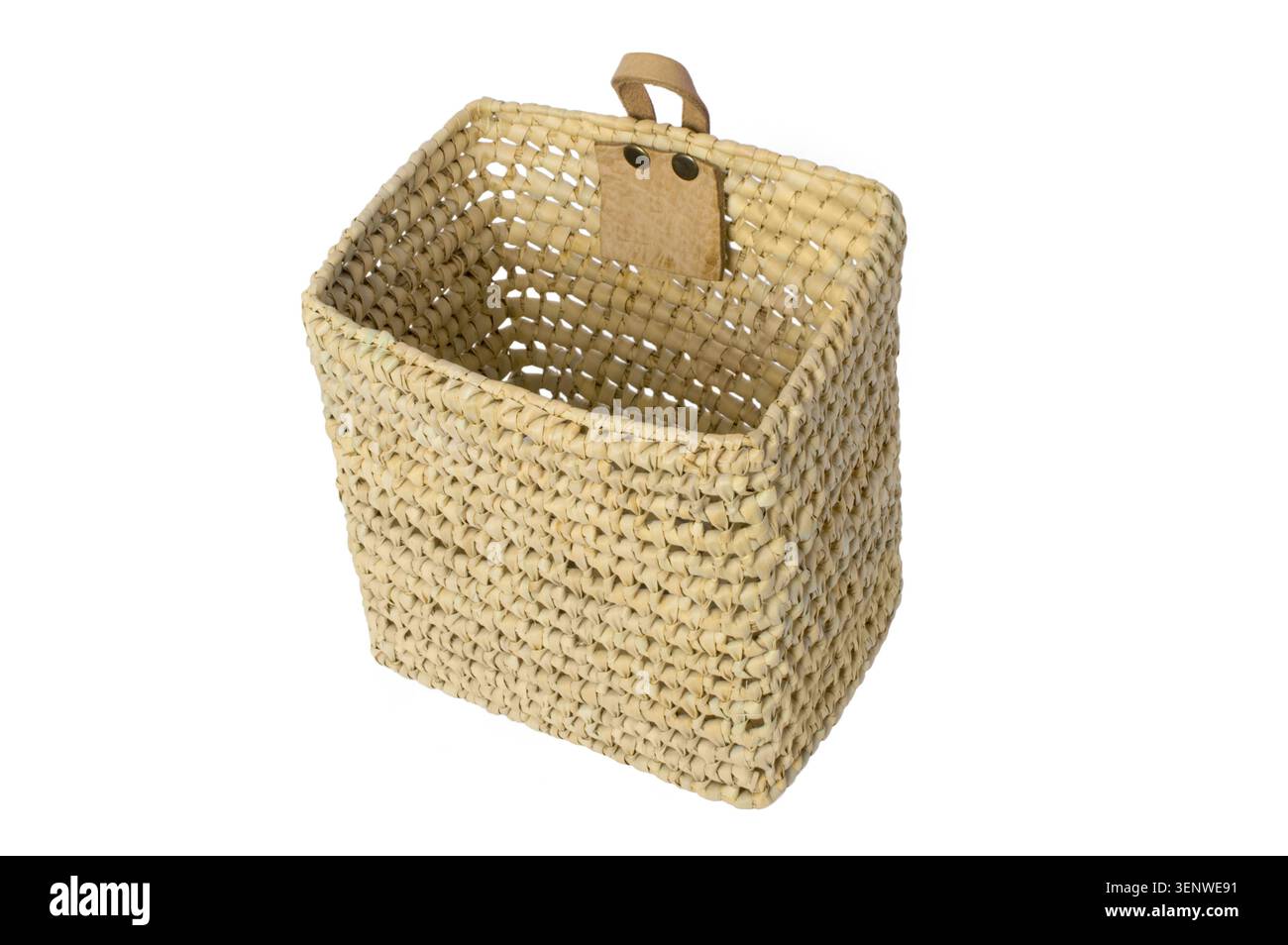 Deep rectangular wicker basket with a leather loop for hanging on the wall. Isolated on a white background. Stock Photo