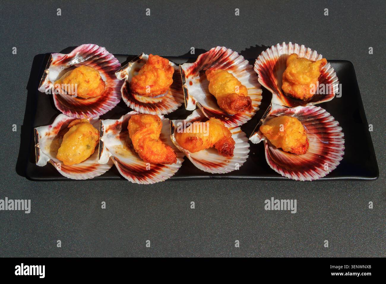 Deep-fried battered scallops in its shell on a table Stock Photo